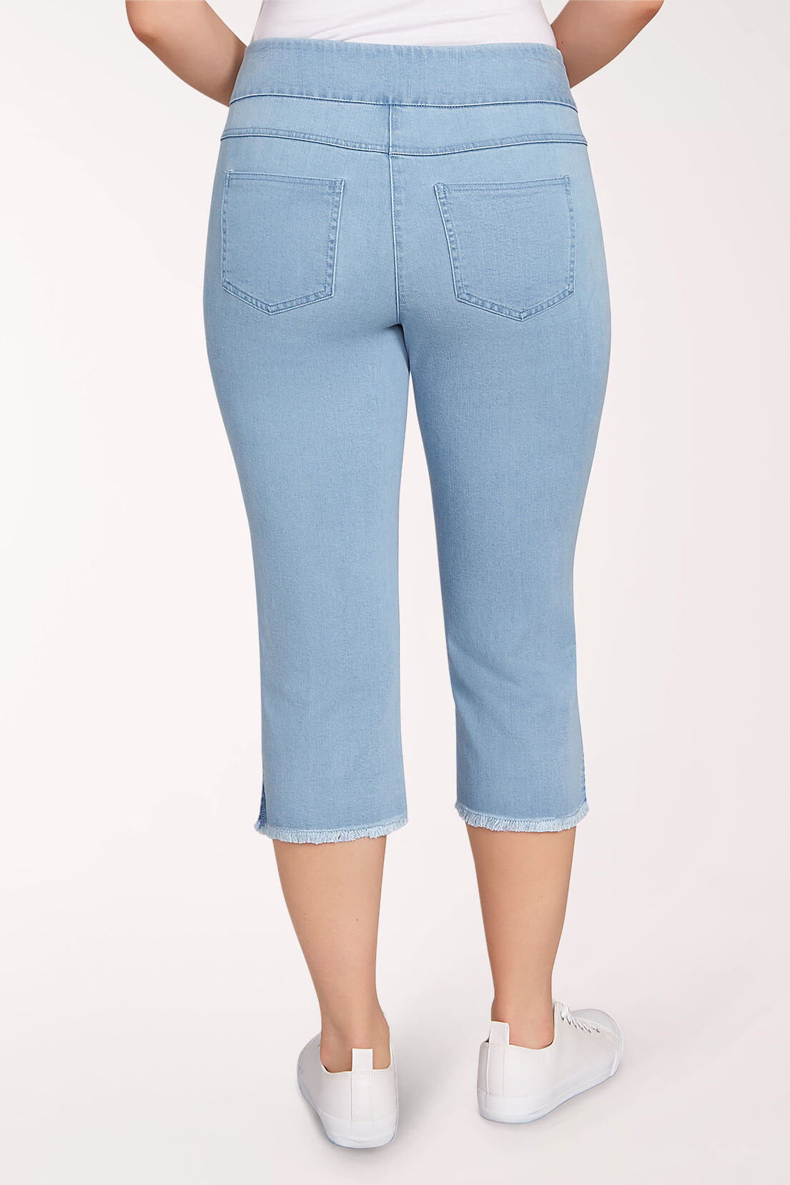 Light blue cropped denim jeans with a frayed hem, shown from the back on a model wearing white sneakers against a plain white background.