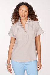 Woman wearing a striped shirt and light blue pants on a white background