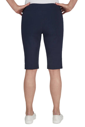 Navy blue shorts worn by a person on a white background