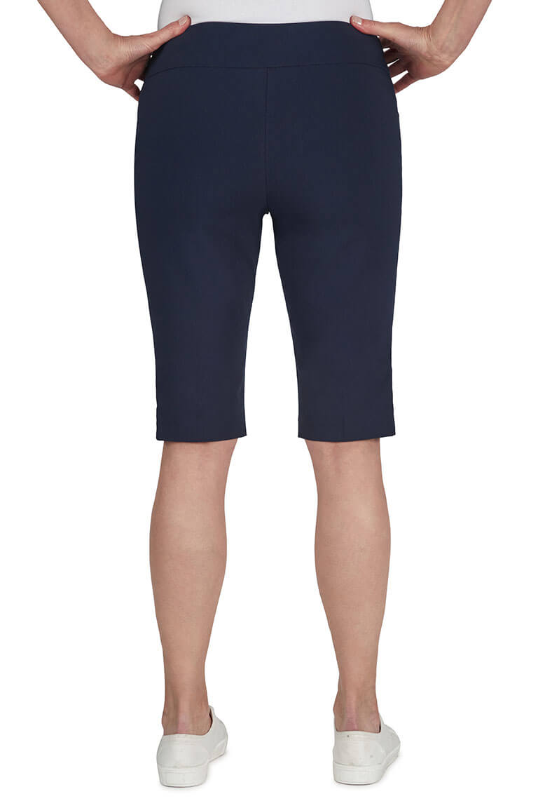 Navy blue shorts worn by a person on a white background