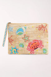 A rectangular zip pouch with a beige woven base, decorated with colorful beaded sea-themed motifs including a pink crab, blue starfish, green shells, and coral, featuring a blue and white patterned zipper pull.