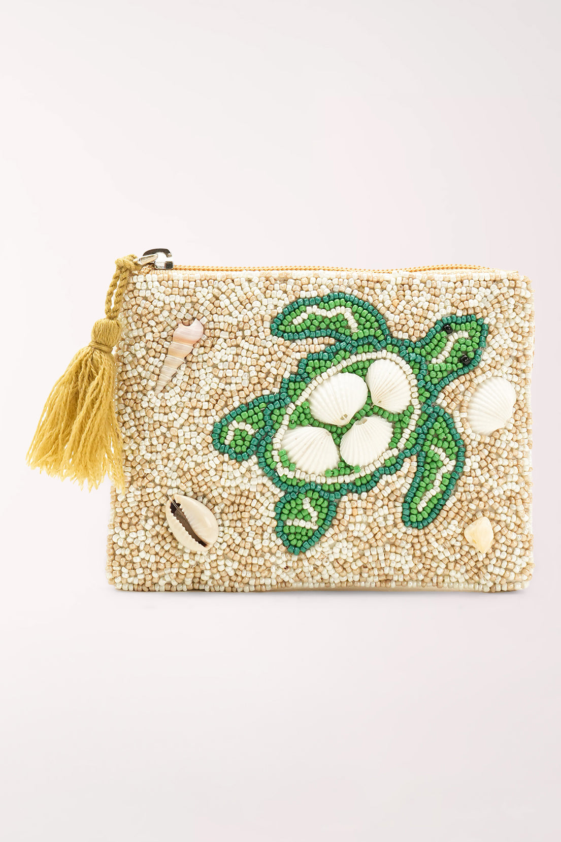 A square zippered clutch bag covered in beige seed beads, featuring a green turtle design with white shell details, small seashell embellishments, and a yellow tassel on the zipper.