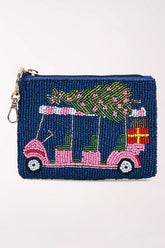 Front view of a navy beaded coin pouch showing a pink golf cart carrying a green Christmas tree and a red wrapped gift, with a gold zipper pull, key ring and dog hook.