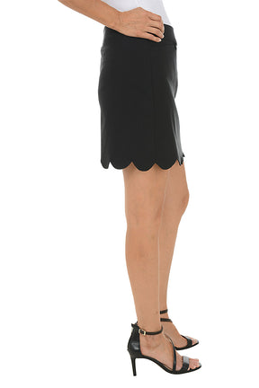 Black scalloped skirt worn by a person on a white background. Side shot.