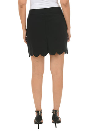 Black scalloped skirt worn by a person on a white background. Back shot.