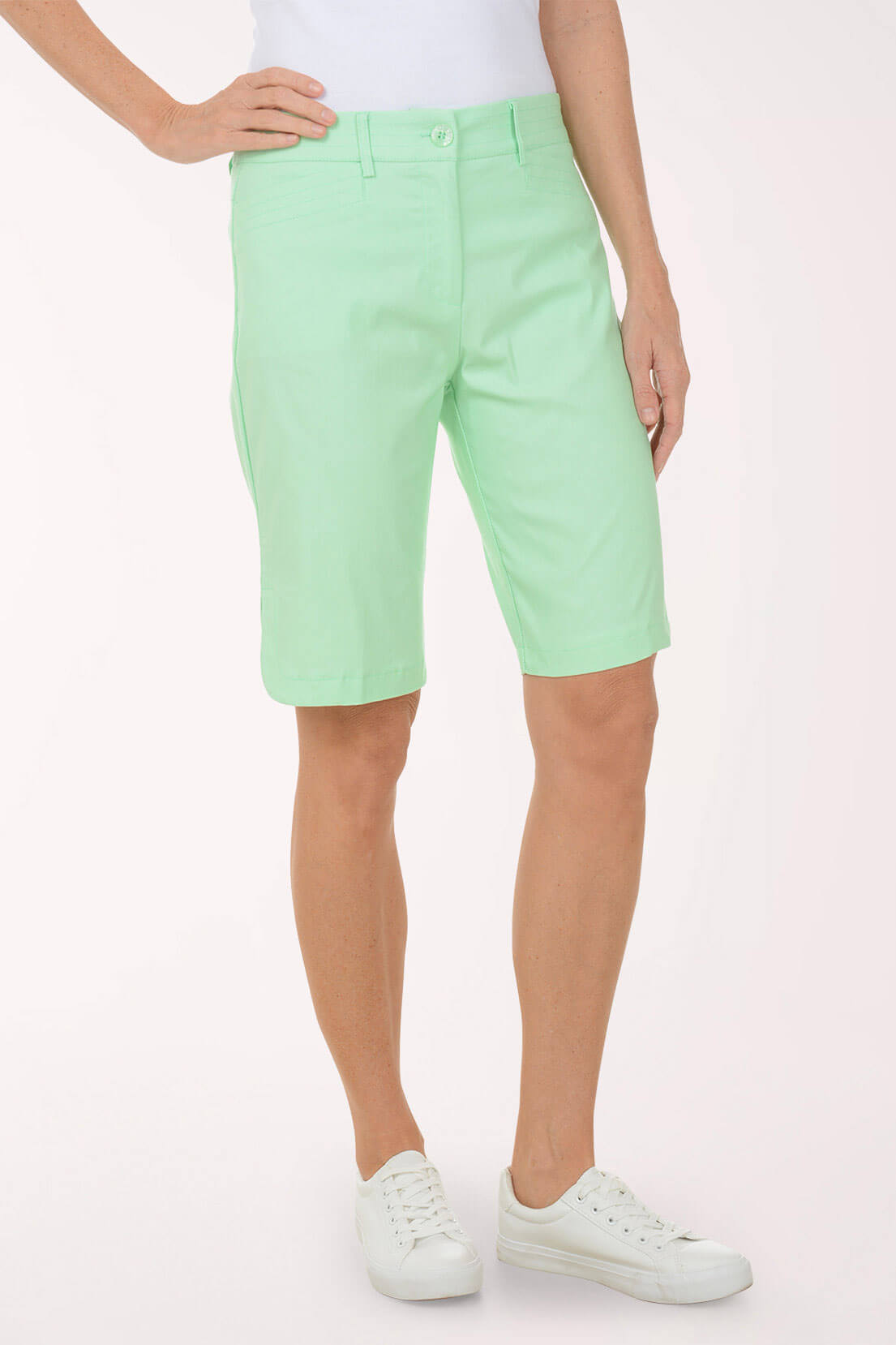 Person wearing light green shorts on a white background