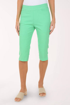 Person wearing green capri pants on a white background