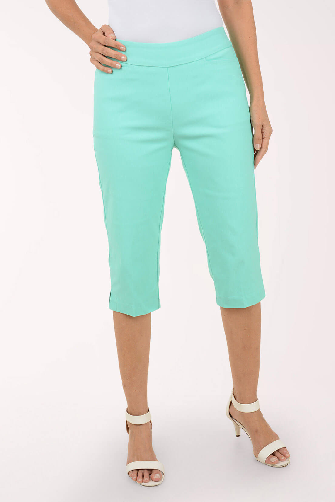 Person wearing light green capri pants on a white background
