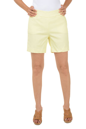 Yellow shorts worn by a person on a white background. 