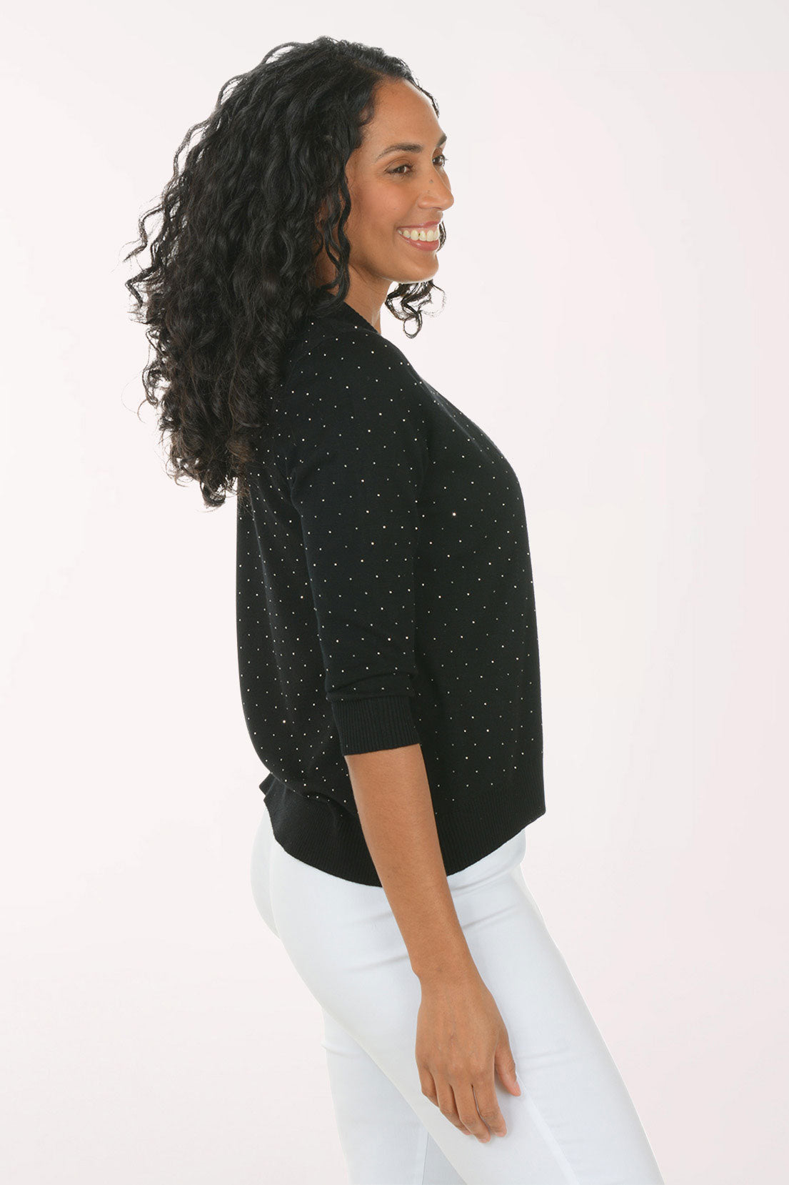 Woman wearing a black cardigan with sequin details on a white background