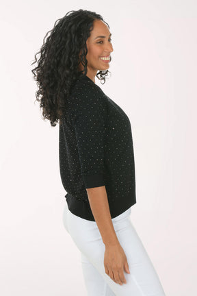 Woman wearing a black cardigan with sequin details on a white background