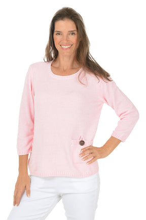 Woman wearing a pink sweater with a button on a white background