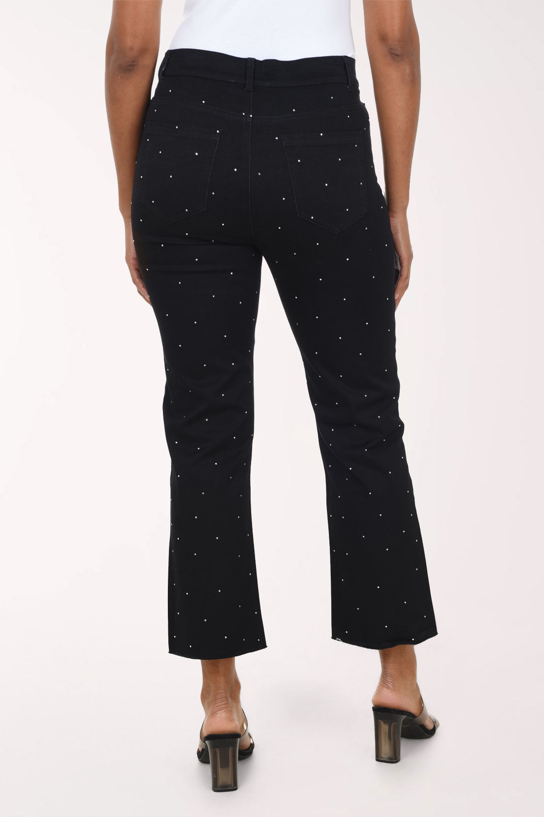 Woman wearing a black crop denim pant with all over jewels 