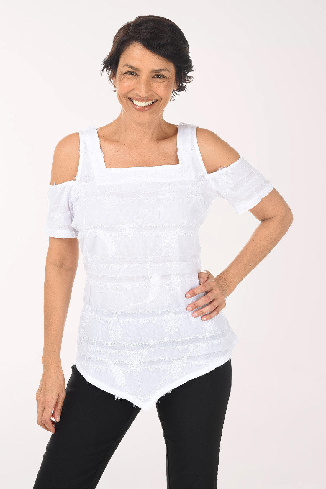 Woman wearing a white off-shoulder top and black pants on a white background