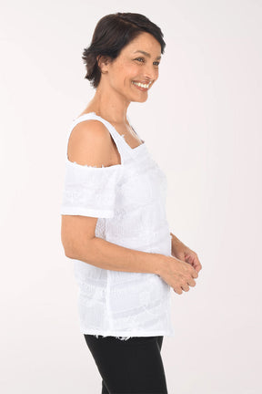 Woman wearing a white off-shoulder top and black pants on a white background
