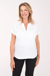 Woman wearing a white blouse and black pants on a white background