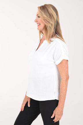 Woman wearing a white blouse and black pants on a white background