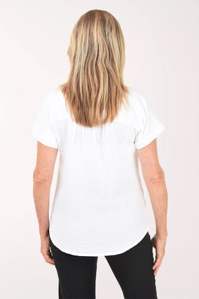 Woman wearing a white blouse and black pants on a white background