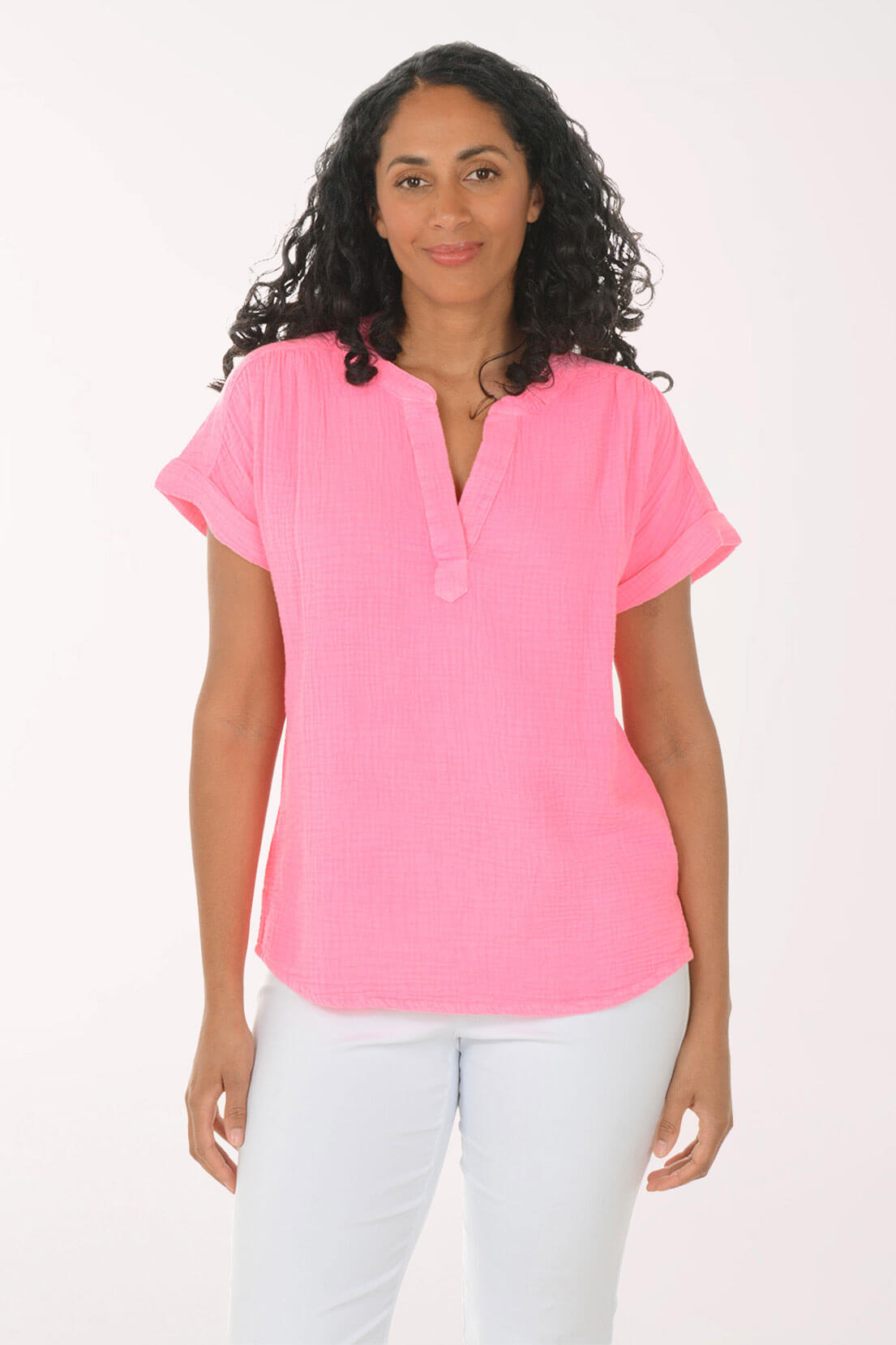 Woman wearing a pink blouse and white pants on a white background