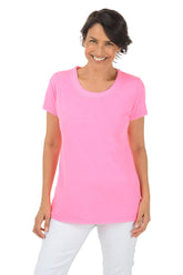 Woman wearing a pink t-shirt and white pants on a white background