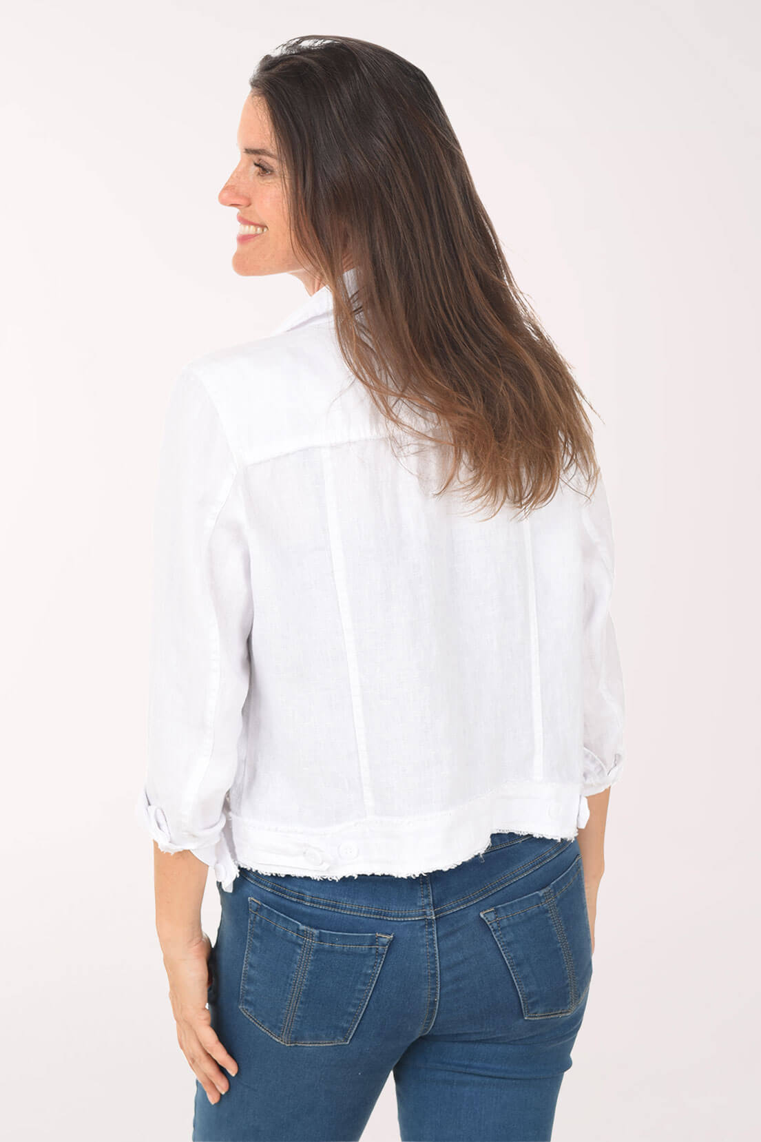 Woman wearing a white blouse and blue jeans on a white background