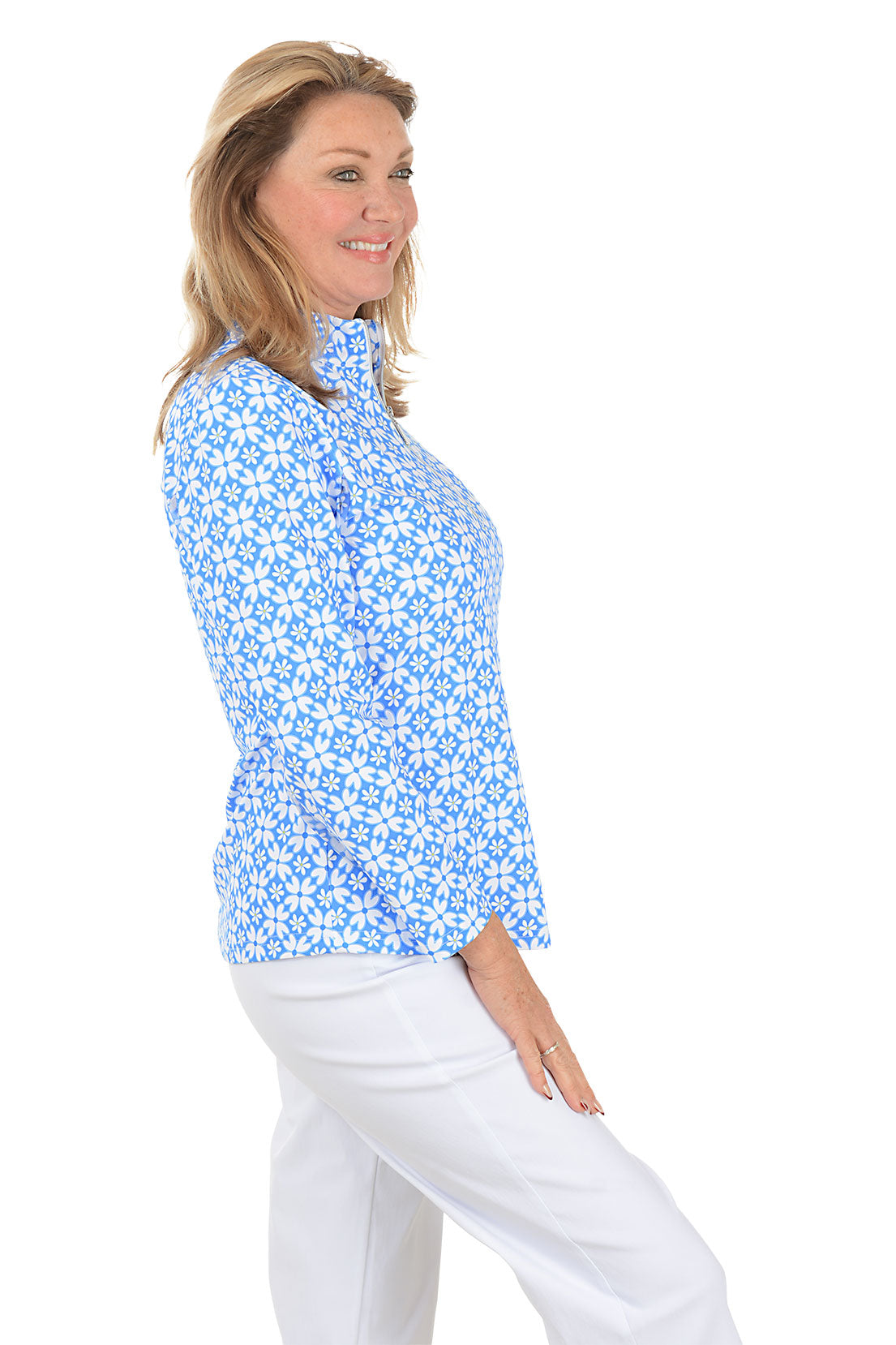 Woman wearing a blue floral patterned shirt on a white background. Side shot.