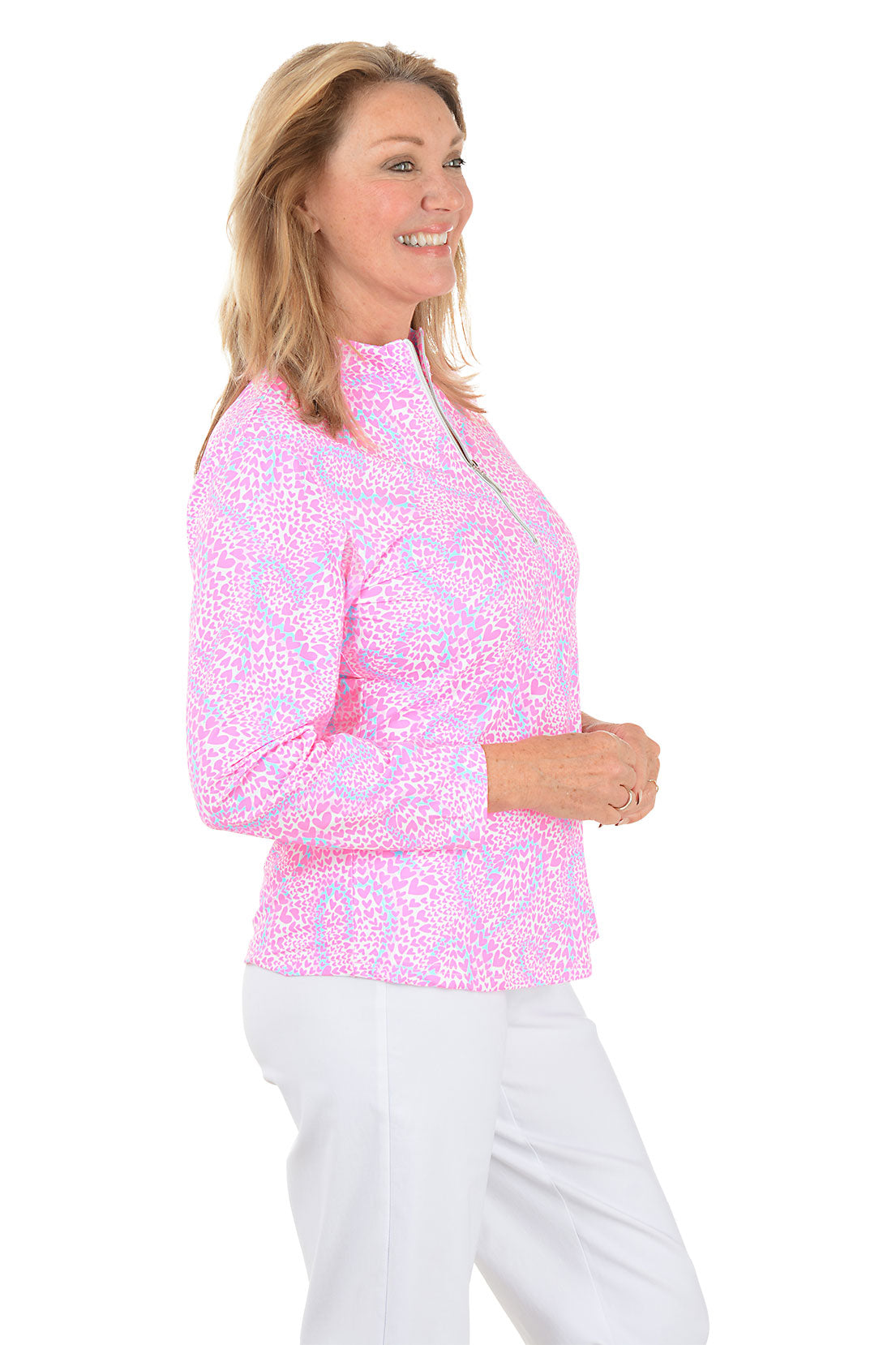 Woman wearing a pink floral long-sleeve top on a white background. Side shot.
