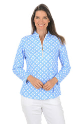 Woman wearing a blue patterned long-sleeve shirt on a white background.