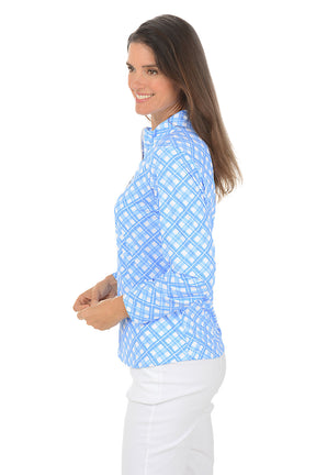 Woman wearing a blue patterned long-sleeve shirt on a white background. Side shot.