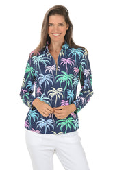 Woman wearing a colorful palm tree patterned shirt on a white background.