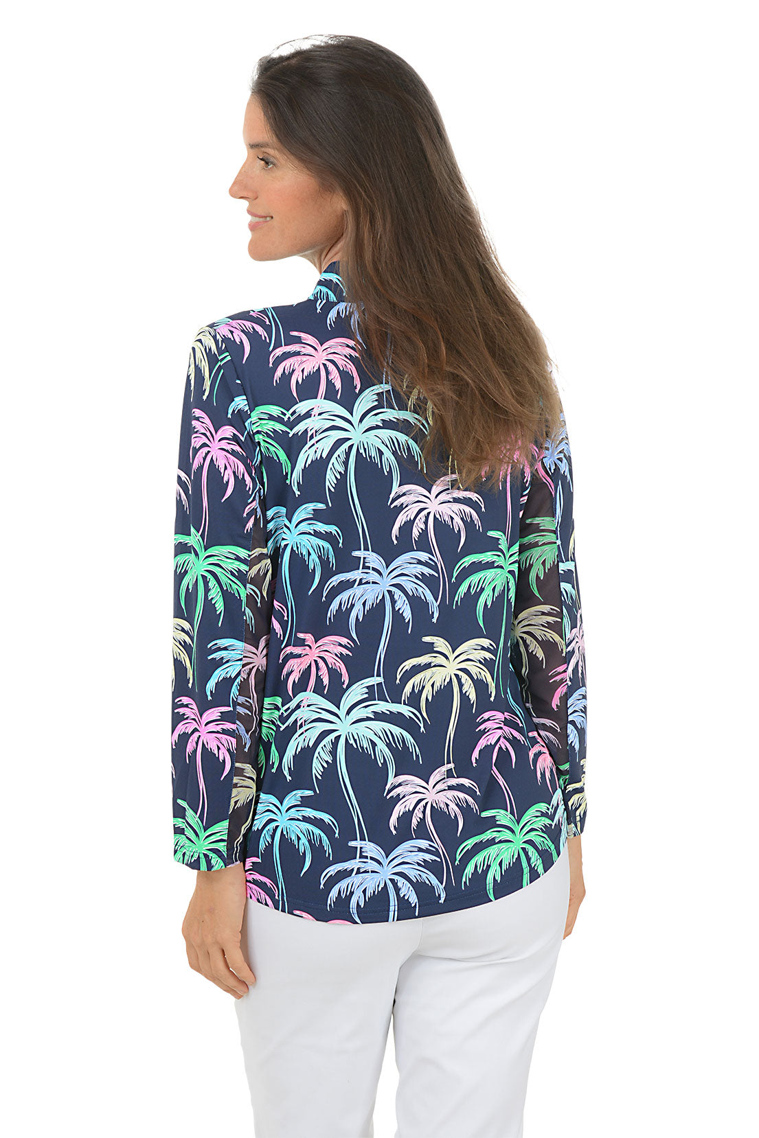 Woman wearing a colorful palm tree patterned shirt on a white background. Back shot.
