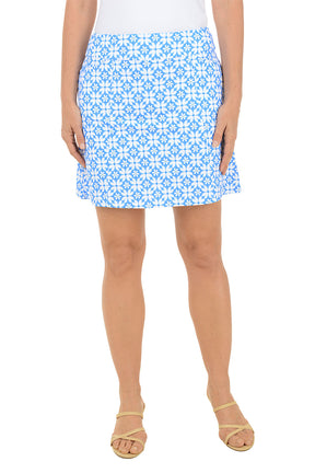 Woman wearing a blue floral patterned skirt on a white background.