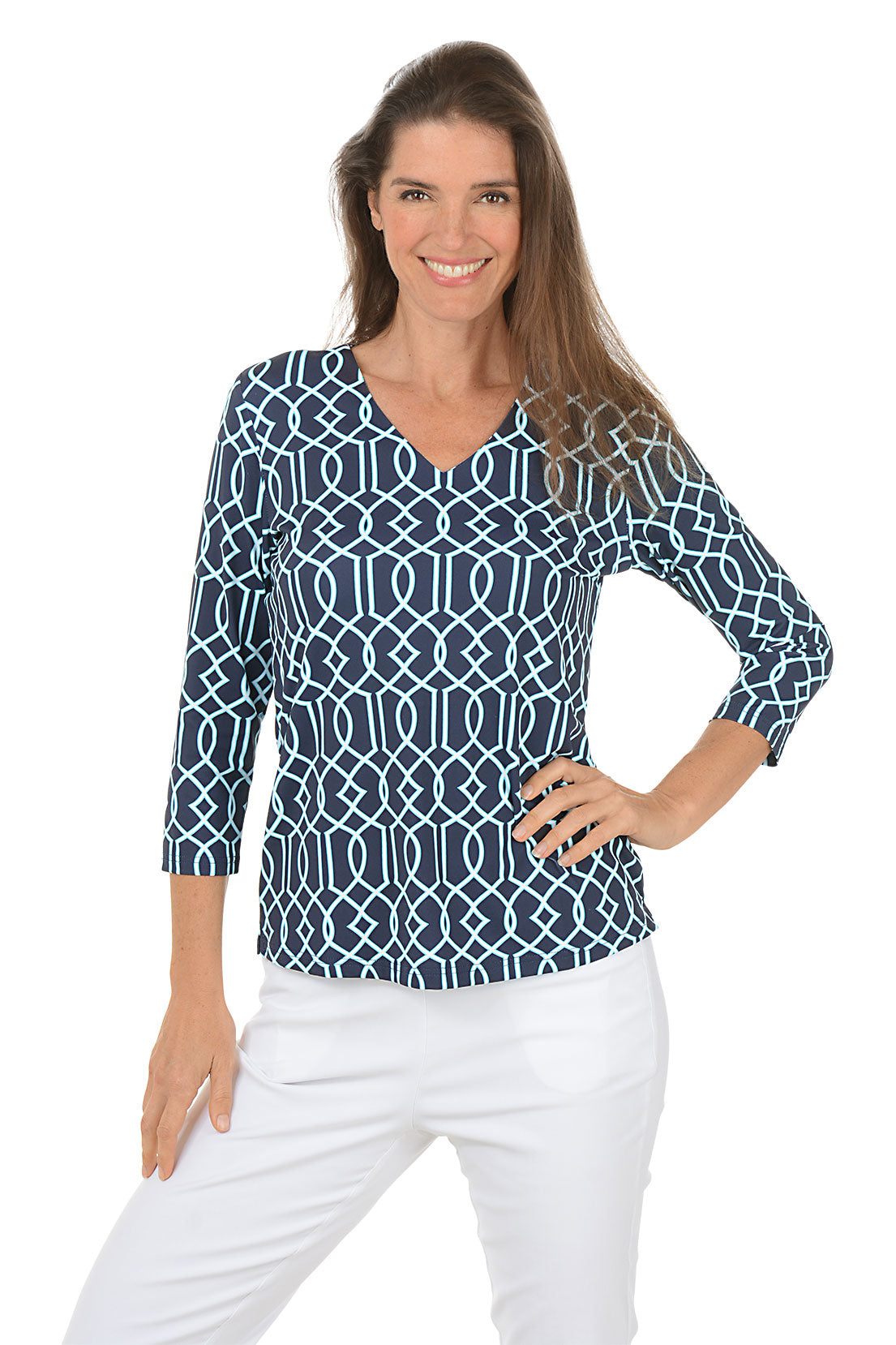 Woman wearing a blue patterned top and white pants on a white background.