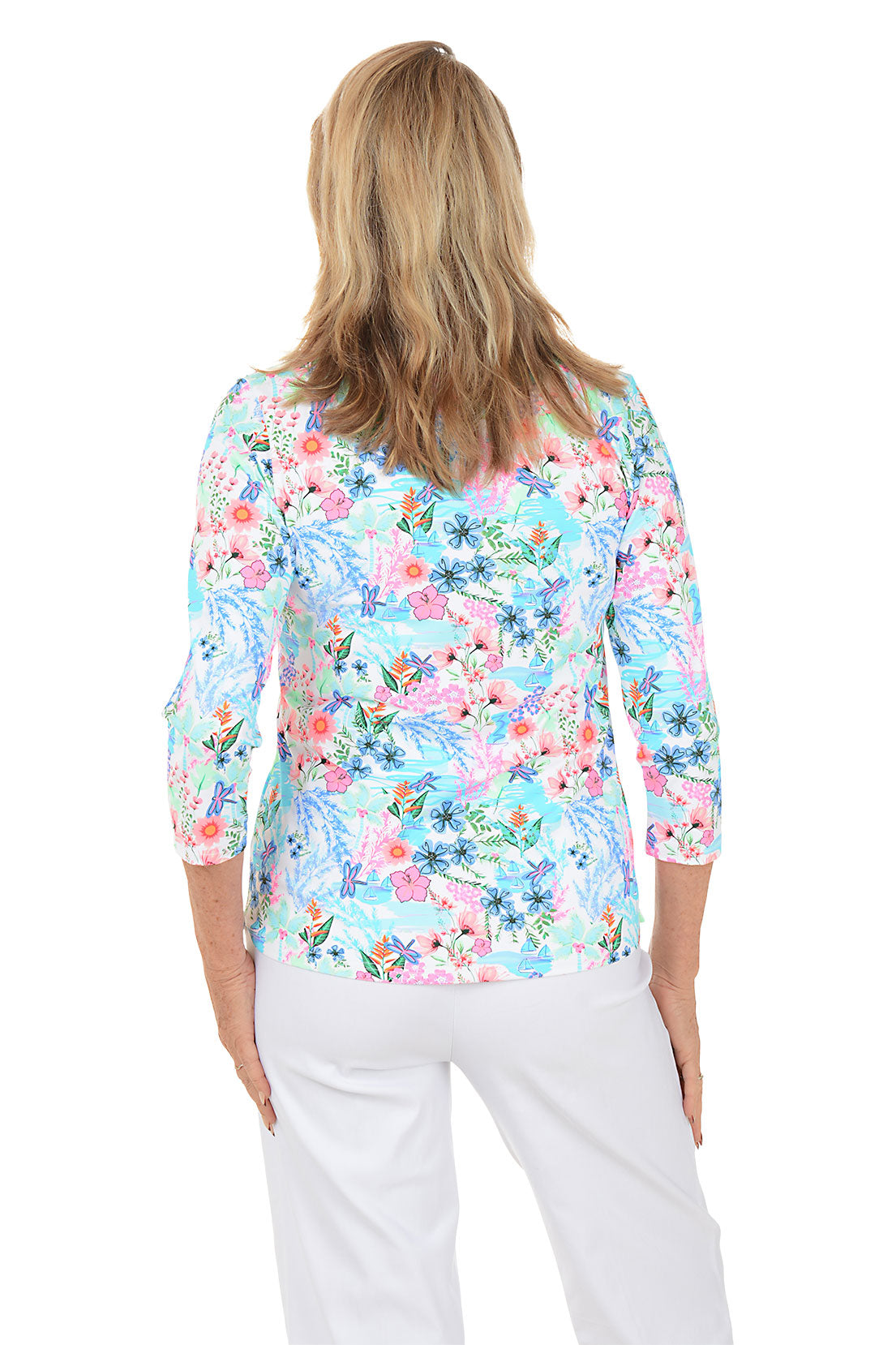 Woman wearing a floral blouse with white pants on a white background. Back shot.
