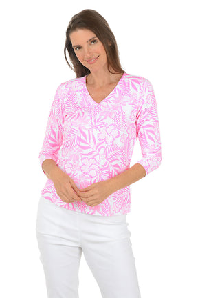 Woman wearing a pink and white patterned blouse with a white background. Second front shot.