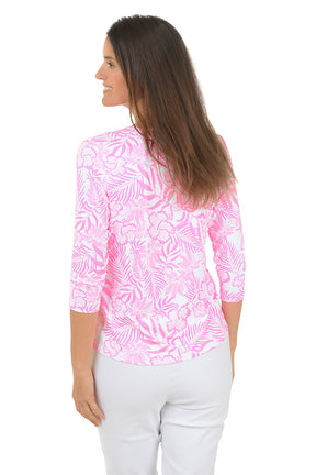 Woman wearing a pink and white patterned blouse with a white background. Back shot.