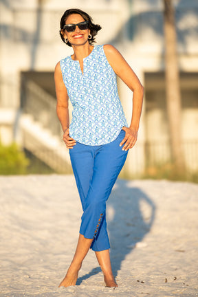 Woman wearing a blue floral top and blue pants standing outdoors.