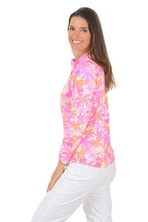Woman wearing a colorful floral long-sleeve shirt on a white background. Side shot.