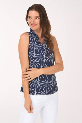 Woman wearing a navy sleeveless top with white palm tree pattern on a white background