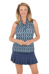 Woman wearing a navy sleeveless top with white geometric pattern and matching skirt on a white background.