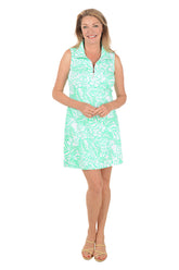 Woman wearing a green patterned dress on a white background.
