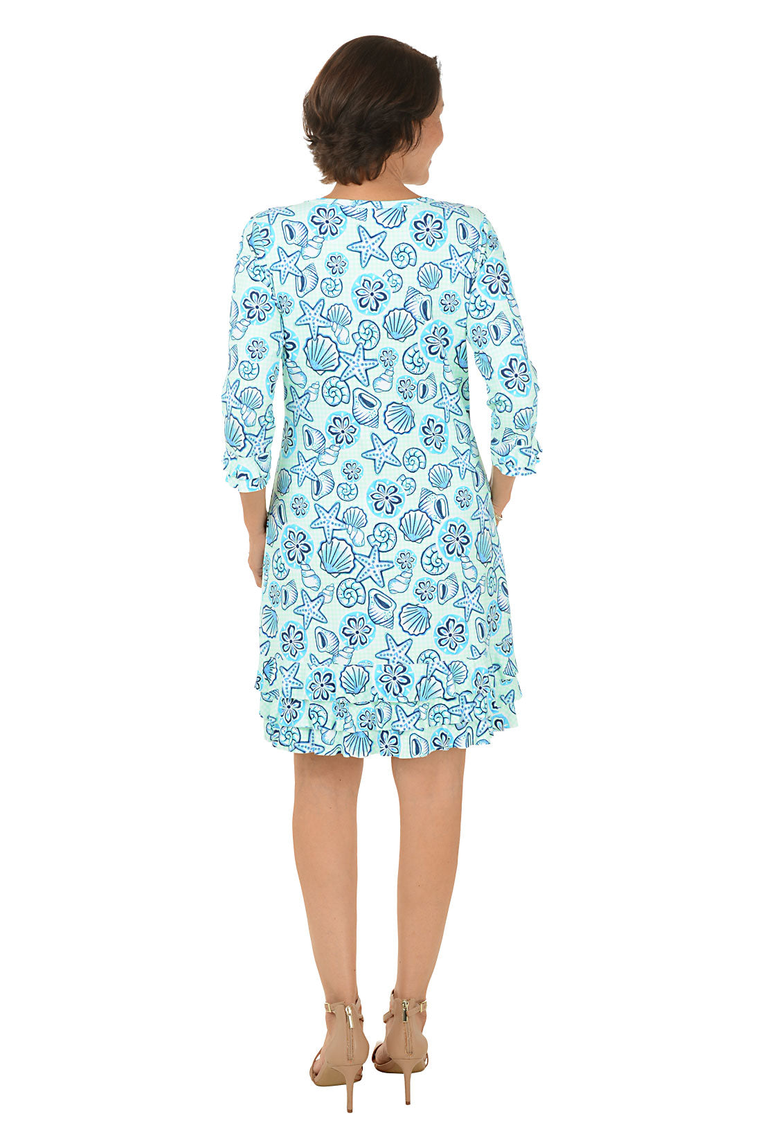 Woman wearing a blue floral dress on a white background.
