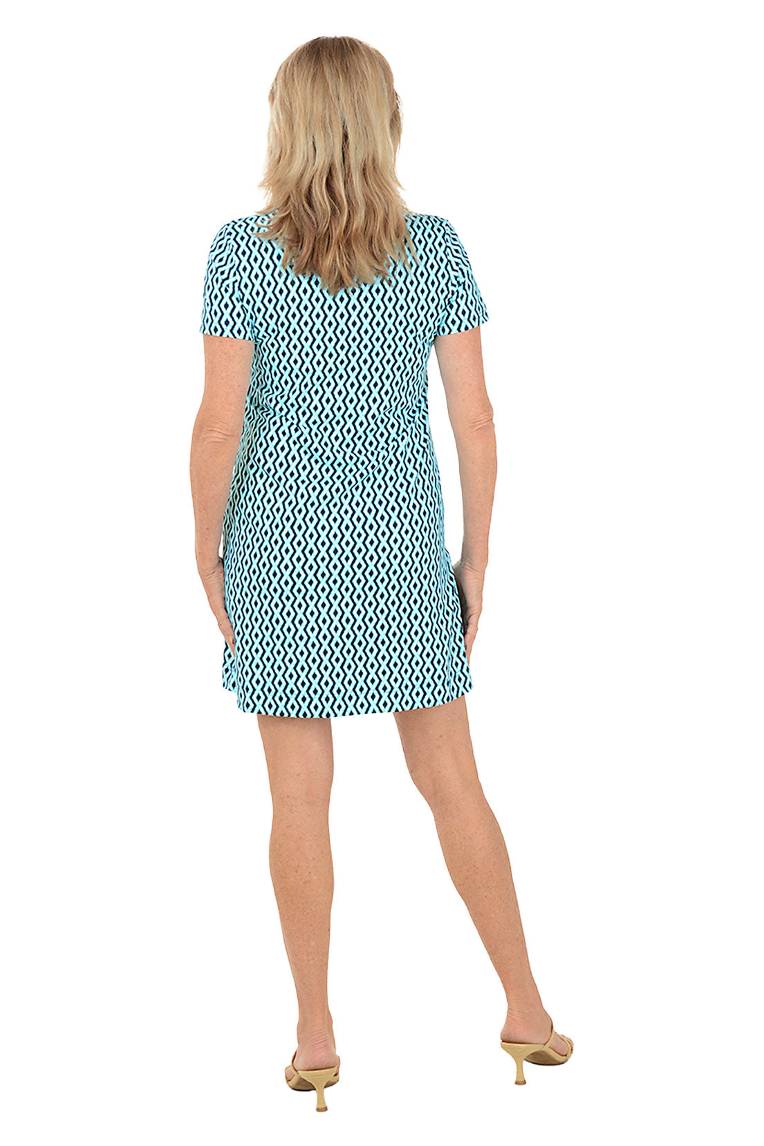 Woman wearing a patterned dress on a white background. Back shot.