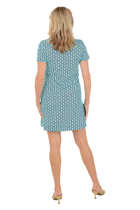 Woman wearing a patterned dress on a white background. Back shot.