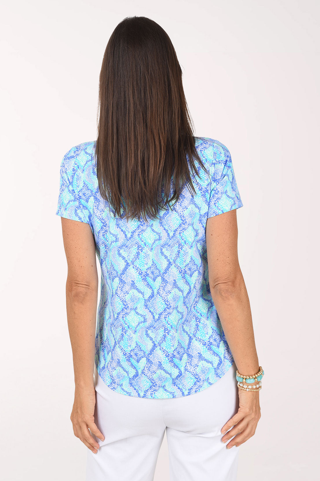 Back view of the Blue Snakeskin Polo Top showing the all-over blue and turquoise snakeskin print and curved hem.