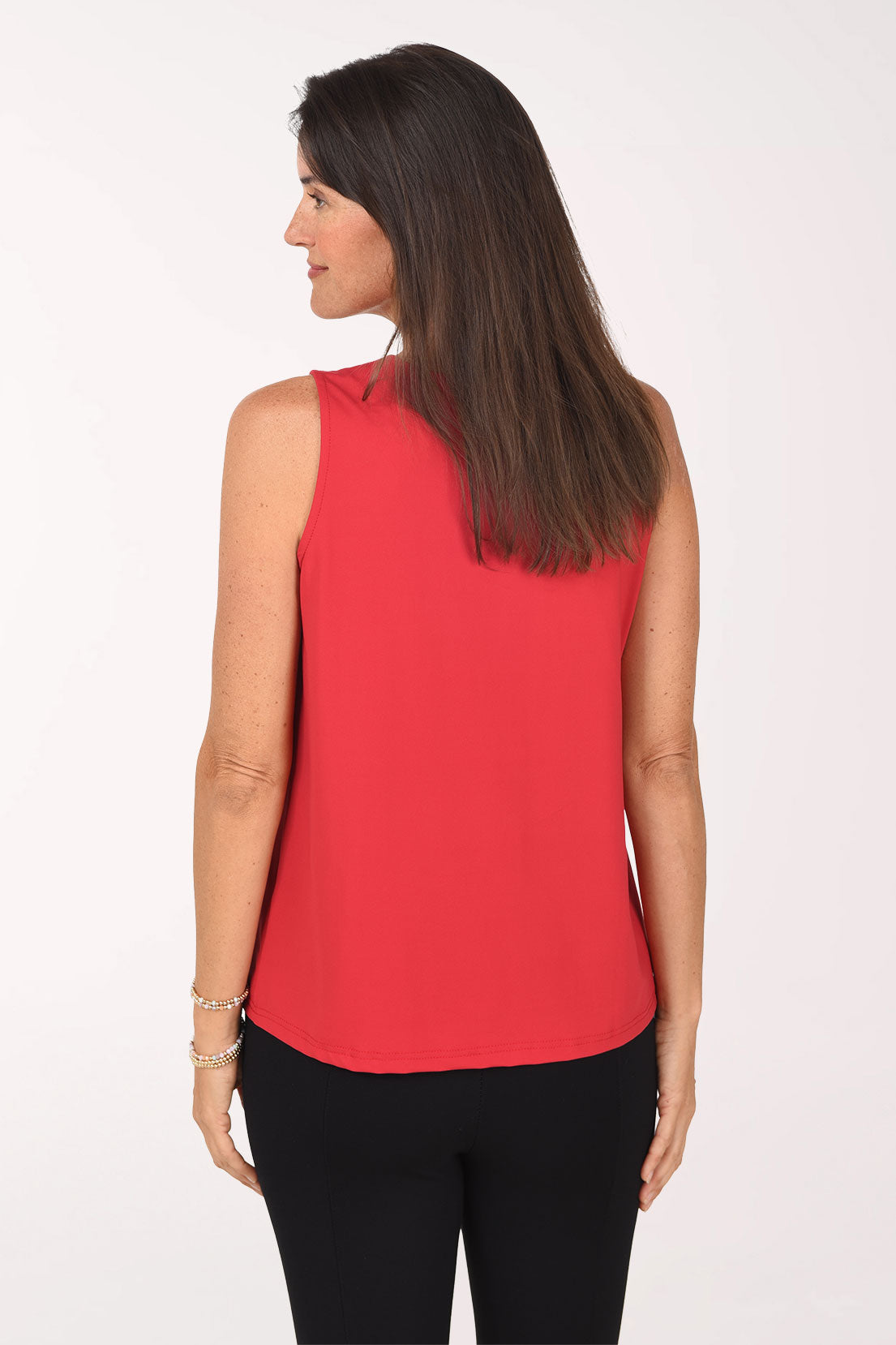 Back view of the crimson Crystal Bow Sleeveless Top showing the plain back and curved hem over black pants.