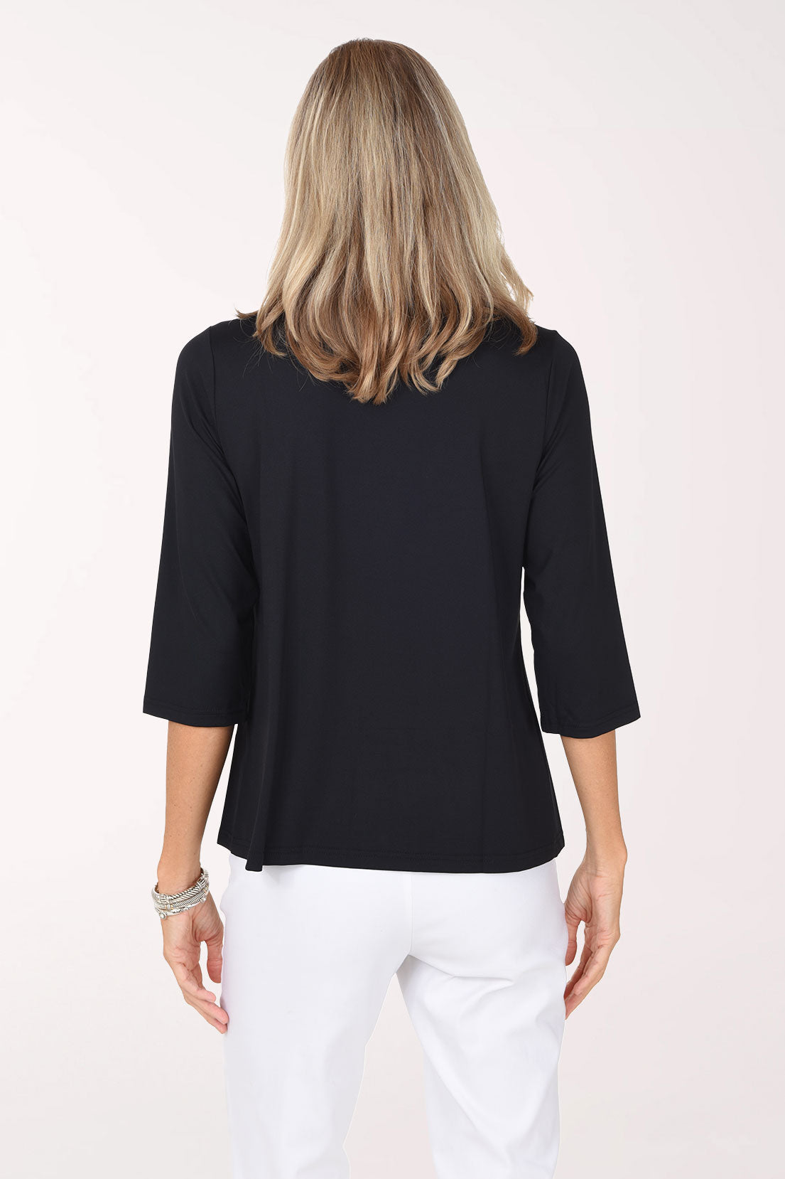 Back view of the black Crystal Bow 3/4 Sleeve Top showing the plain back and straight hem over white pants.