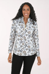 A woman modeling a white long-sleeve quarter-zip performance top with a black and brown starfish and shell pattern, paired with black pants, against a solid off-white background.