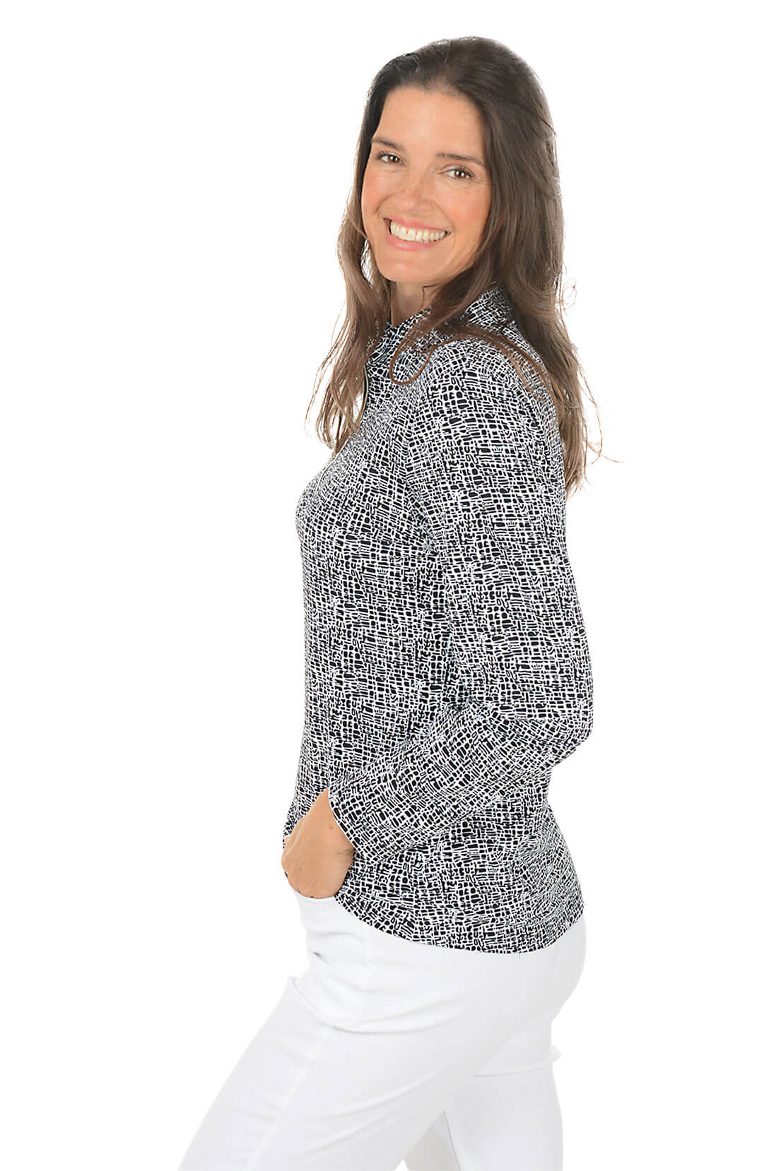 Woman wearing a black and white patterned blouse with white pants on a white background