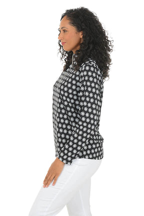 Woman wearing a black and white patterned sun shirt with a zipper on a white background. Side shot.